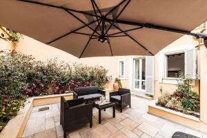 a patio with black furniture and a large umbrella at Dolcevita Apartments in Rome