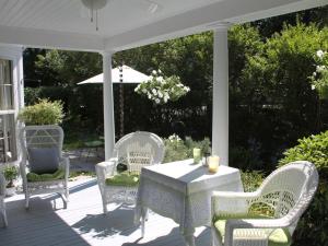 a porch with a table and chairs and an umbrella at The Beech Tree B&B in Rockport