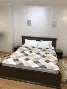 a bed with a white comforter and pillows at Red Stone in Truskavets