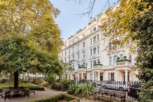 a white building with benches in front of it at Mercure London Hyde Park Hotel in London