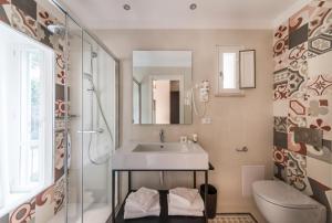 łazienka z umywalką, prysznicem i toaletą w obiekcie Dolcevita Apartments w Rzymie +26 zdjęć