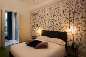 1 dormitorio con 1 cama con papel pintado en blanco y negro en Le Tre Madame, en Turín