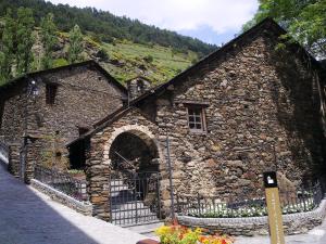 a stone building with a window and a fence at Tarter Confort in El Tarter