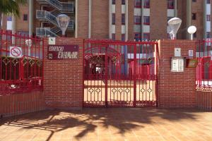 una puerta roja frente a un edificio de ladrillo en Evamar Apartments, en Benidorm