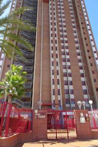 ベニドルムにあるEvamar Apartmentsの高い建物前の赤い柵