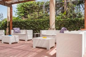 un patio con tavoli e sedie in vimini bianchi di Solemare Residence a Donnalucata