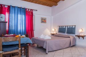 a bedroom with two beds and red and blue curtains at Solemare Residence in Donnalucata