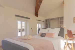 a bedroom with a white bed and white walls at Maloc Agen Centre in Agen