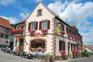 a large brick building with a clock on the front of it at Hôtel Restaurant Kleiber in Saint-Jean-Saverne