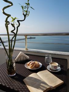 einen Tisch mit einem Teller Donuts und einer Tasse Kaffee in der Unterkunft Hotel Edart in Durrës