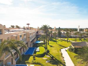 an aerial view of the courtyard of a building with palm trees at AQI Skanes Resort in Monastir