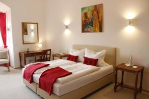 a bedroom with a large bed with red pillows at Schlosshotel Kirchberg in Kirchberg an der Jagst
