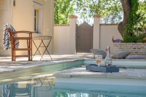 una botella de vino y una copa junto a la piscina en Carpofoli Corfu en Corfú