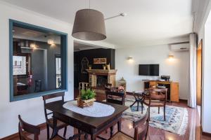 sala de estar con mesa, sillas y chimenea en Lindo Vale Guest House, en Oporto