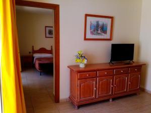 a room with a television on a dresser and a mirror at Parque carolina estudio 203 in Costa Del Silencio