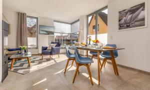 a dining room and living room with a table and chairs at Haus Liesing in Prerow