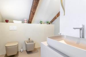 a bathroom with a white tub and a toilet at Pgrhome Luxury Apartments Coral Loft Venice in Venice