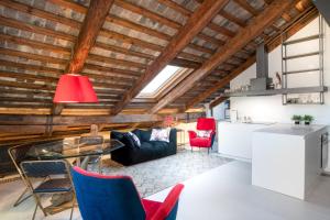 a kitchen and living room with wooden ceilings and red chairs at Pgrhome Luxury Apartments Coral Loft Venice in Venice