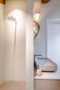 two images of a bathroom with a sink and a lamp at Pgrhome Luxury Apartments Coral Loft Venice in Venice