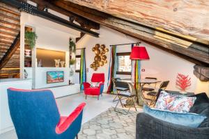 Pgrhome Luxury Apartments Coral Loft Venice في البندقية: غرفة معيشة مع كراسي وطاولة