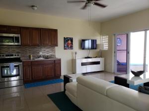 a living room with a couch and a kitchen at Villa Indigo Sunny 1BR Apartment in Private Gated Estate in Charlotte Amalie
