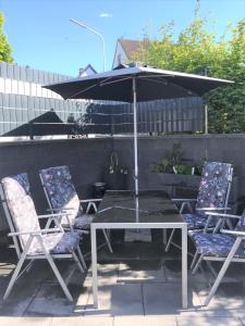 a patio table with two chairs and an umbrella at Ferienhaus Adele in Bad Neuenahr-Ahrweiler