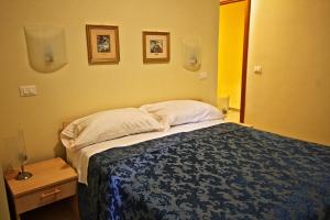 a bedroom with a bed and two pictures on the wall at Il Cantinone Rooms in Castelnuovo di Farfa