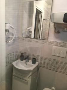 ein Bad mit einem Waschbecken und einem Spiegel in der Unterkunft VICOLOVOLTA16 in Torri del Benaco