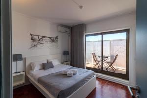 a bedroom with a bed and a large window at Lindo Vale Guest House in Porto