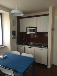 eine Küche mit einem blauen Tisch und weißen Schränken in der Unterkunft VICOLOVOLTA16 in Torri del Benaco