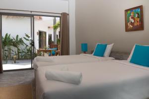 two white beds in a room with a patio at Secret Garden Beach Resort in Bangrak Beach