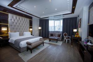a large bedroom with a large bed and a chair at Sapphire Hotel in Baku