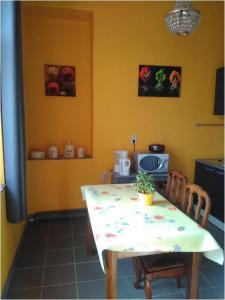 a kitchen with a table and two chairs and a table andheasternheasternheasternheastern at Chez Caro in Epinois +5 photos
