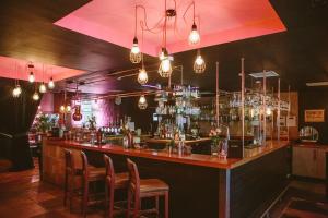 a bar with chairs and a counter with drinks at Glasgow Grosvenor Hotel in Glasgow