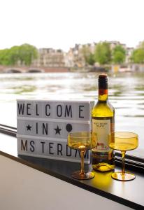 a bottle of wine and two glasses on a ledge at Houseboat Amsterdam - Room with a view in Amsterdam