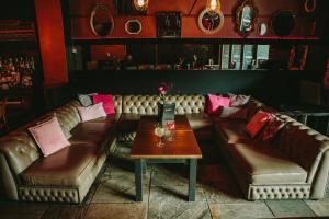 a living room with brown leather couches and a table at Glasgow Grosvenor Hotel in Glasgow