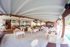 ein Restaurant mit weißen Tischen und Stühlen sowie Tischen in der Unterkunft Motel Plaza in Jajce