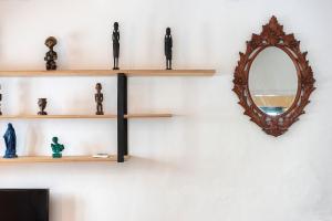 a wall with wooden shelves and a mirror at Casa Brigitte - Califa Casas Vejer in Vejer de la Frontera