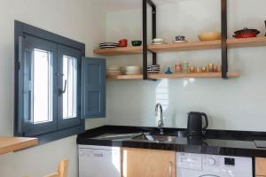 a kitchen with a sink and a washing machine at Casa Brigitte - Califa Casas Vejer in Vejer de la Frontera