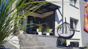 a porch with potted plants and a swing at Villa Lavendowa in Jastrzębia Góra