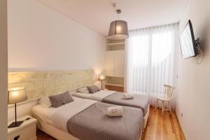 a hotel room with a bed and two lamps at Lindo Vale Guest House in Porto