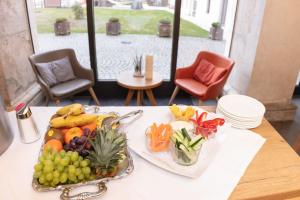 a table with a plate of fruit and vegetables on it at JUFA Hotel Spital am Pyhrn in Spital am Pyhrn