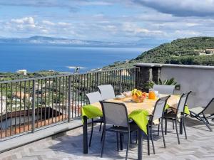 een tafel en stoelen op een balkon met uitzicht op de oceaan bij La Lobra Dépendance in Massa Lubrense