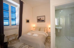 a small bedroom with a bed and a bathroom at The Maltese Sun in Sliema