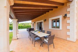 een buitenterras met een tafel en stoelen bij Finca Roca Blanca in S'Horta