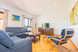 een woonkamer met een bank, een tafel en een stoel bij Finca Roca Blanca in S'Horta