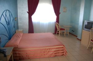 1 dormitorio con 1 cama, TV y ventana en Hotel Club Pegaso, en Marina di Melilli