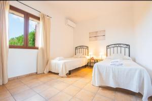 een witte kamer met 2 bedden en een raam bij Finca Roca Blanca in S'Horta +48 foto's