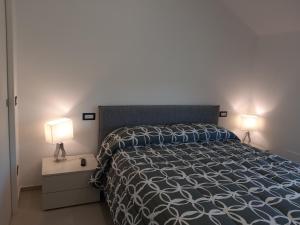 a bedroom with a bed with two lamps on it at La Lobra Dépendance in Massa Lubrense