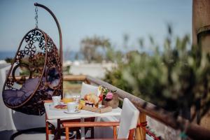 a table with a basket of food on a balcony at Pueblo Viejo Suites in Kamari